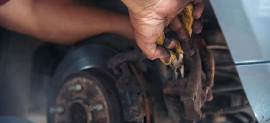 Auto Mechanic Repairing Brake Pads on Car